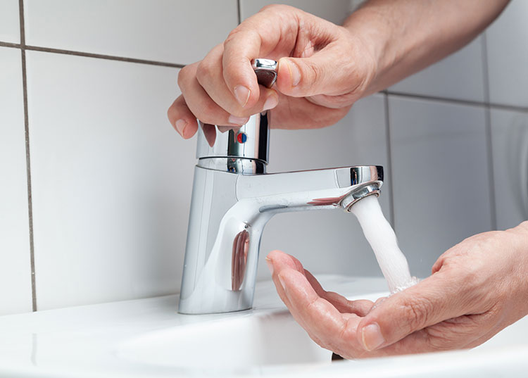 Man using new tap after plumbing services